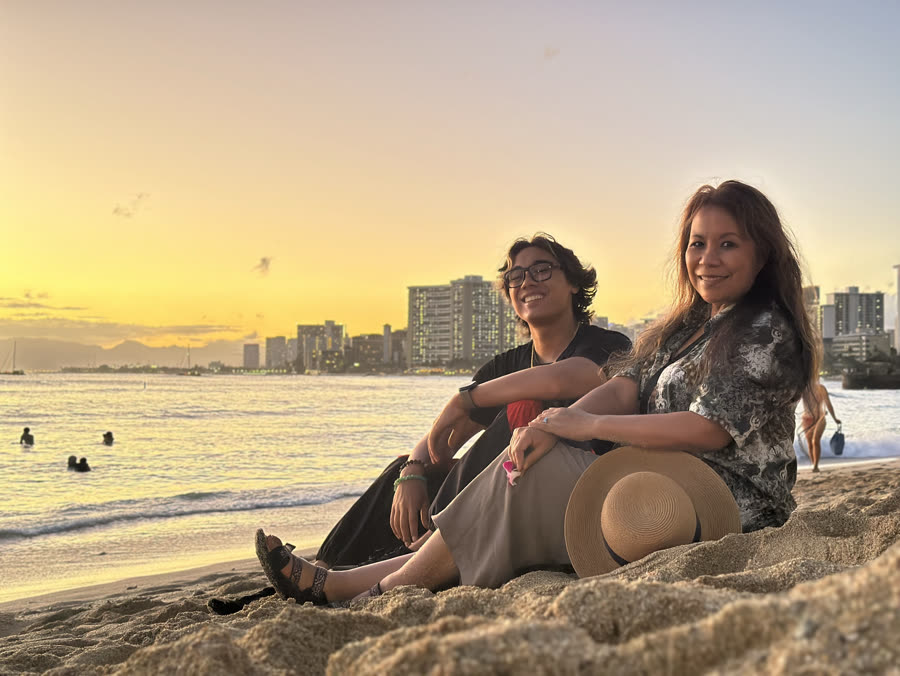 Two people on the sand at sunset