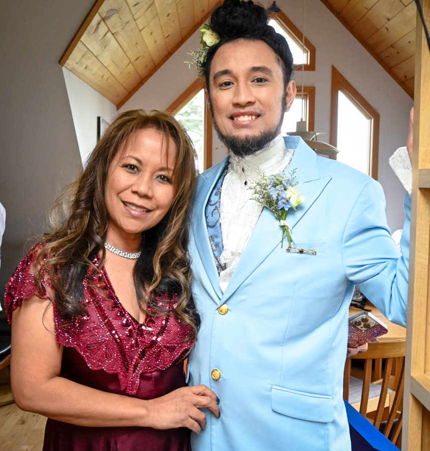 A groom in a powder-blue suit with his mother before the ceremony