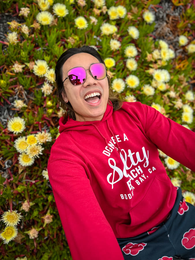 Someone laughing against a wall of yellow and white blooms