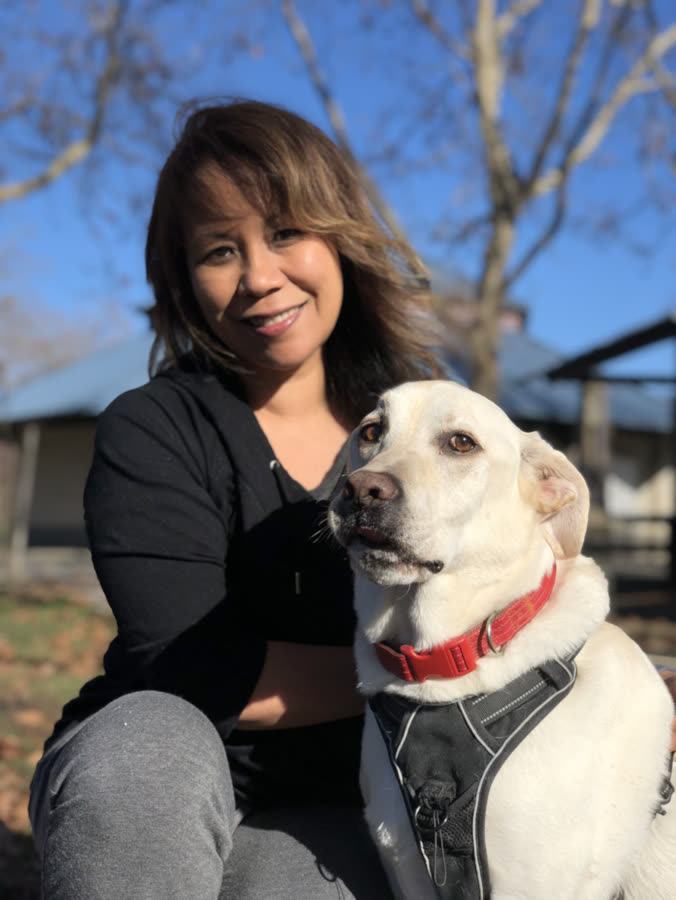 A woman and her yellow lab on a crisp autumn afternoon