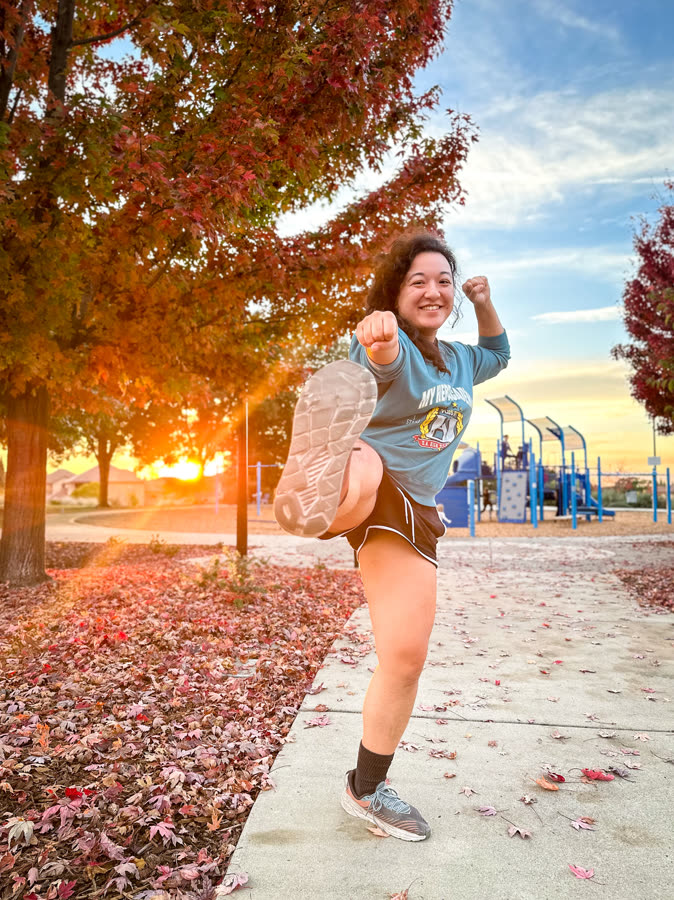 A joyful mid-stride moment on a leaf-covered path