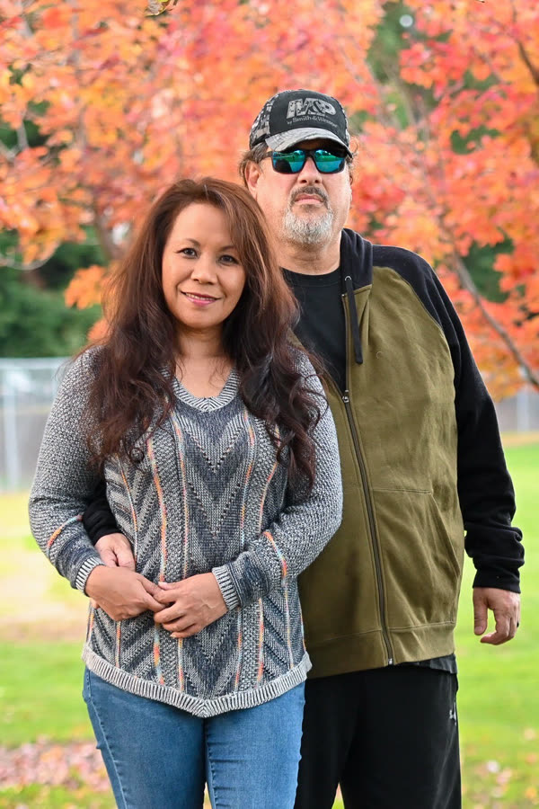 A couple standing beneath a red maple