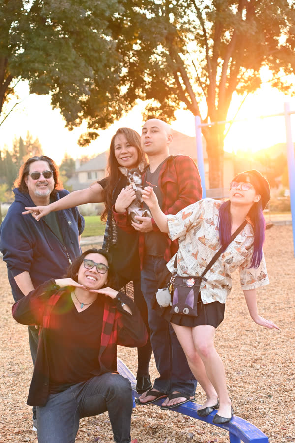 A family posing playfully as the sun sets behind them