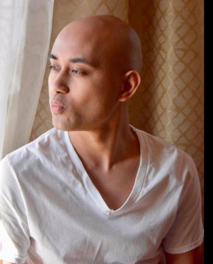 Portrait of a man in a white t-shirt turned toward soft window light